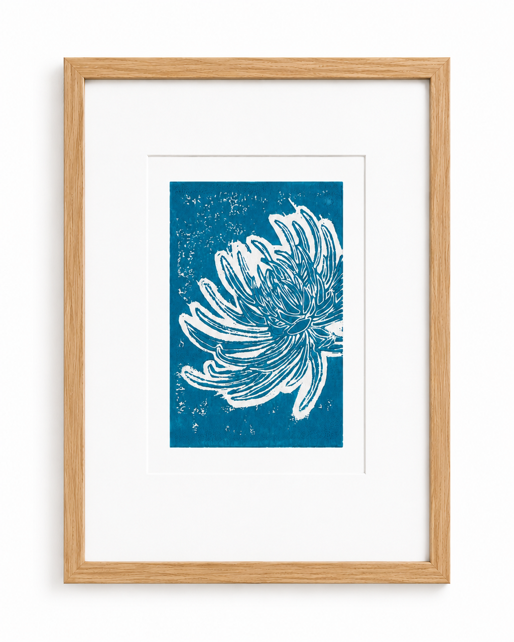 Original turquoise chrysanthemum linocut print on A4 paper shown in a slim light oak frame against a clean white background.