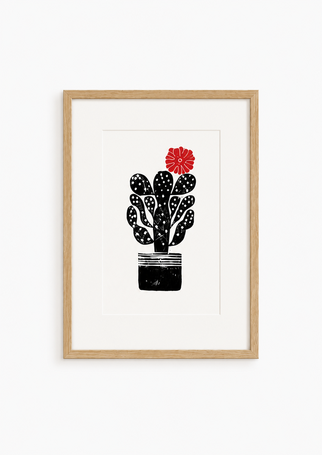 handmade linocut print of a cactus with a flower in black and red ink, A4 size, signed artwork on a plain white background