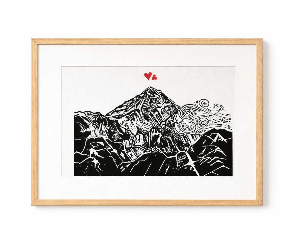Handmade linocut mountain and love heart print, framed, black and red ink on white textured paper, A4 size, set on a plain white background