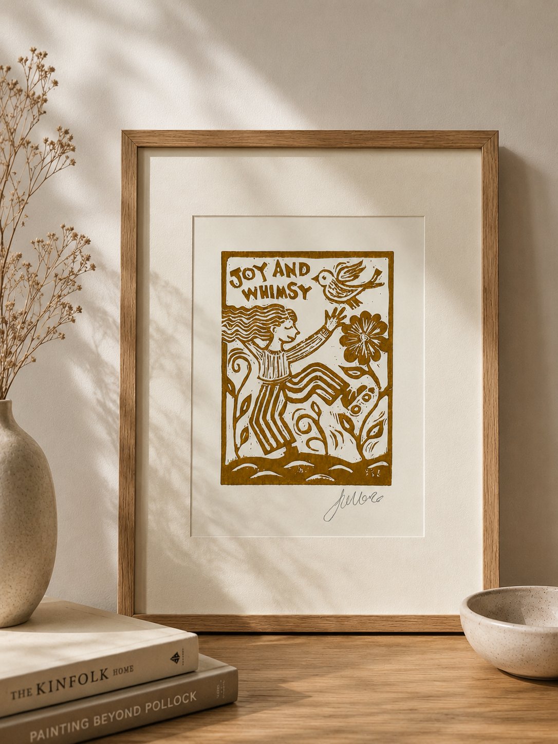 Framed artwork with 'Joy and Whimsy' text and illustrations on a neutral background