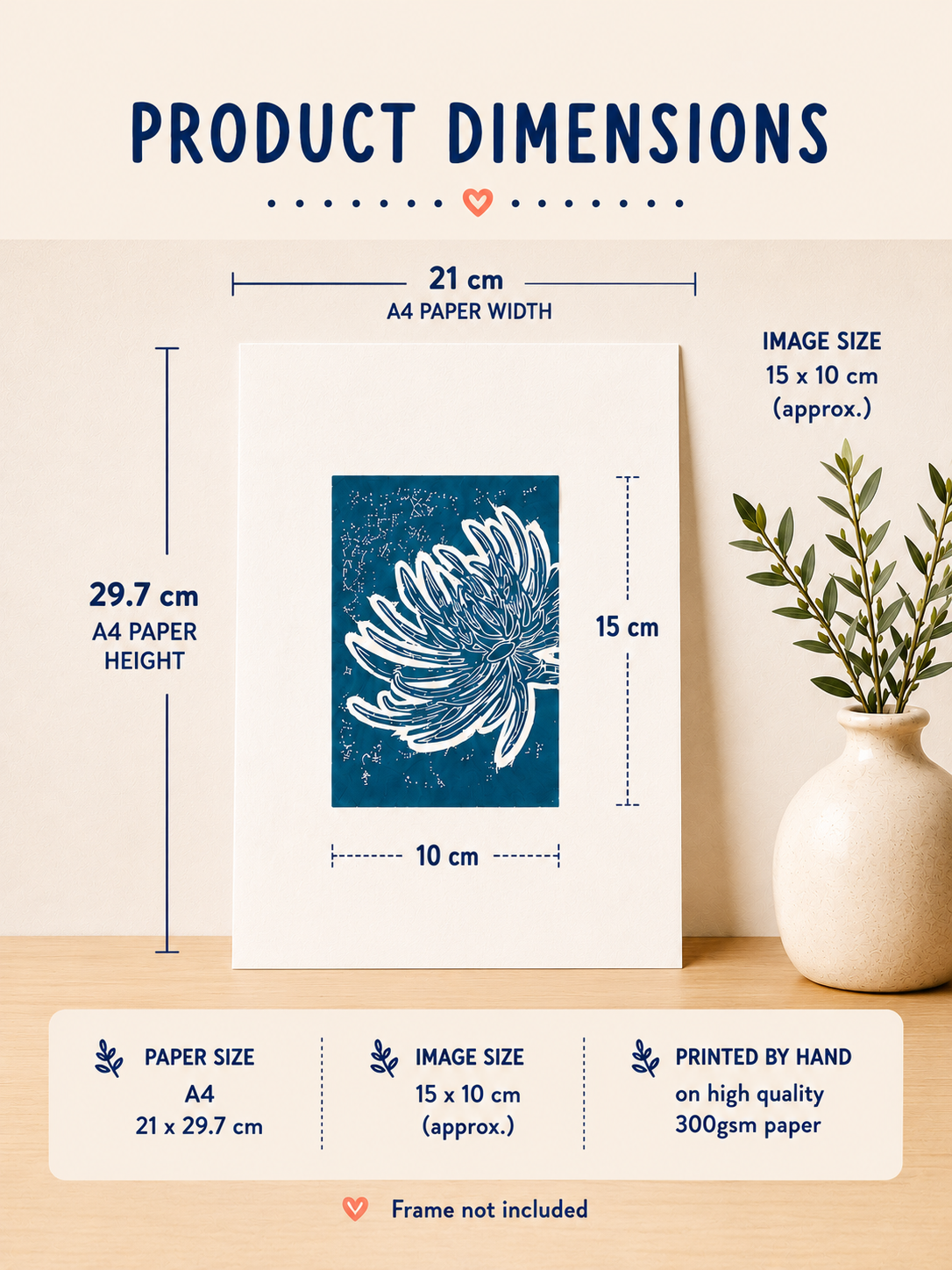 Product dimensions diagram for a framed art print featuring a blue floral linocut-style design on white paper. The print is shown standing on a light wood surface beside a small beige vase with greenery.