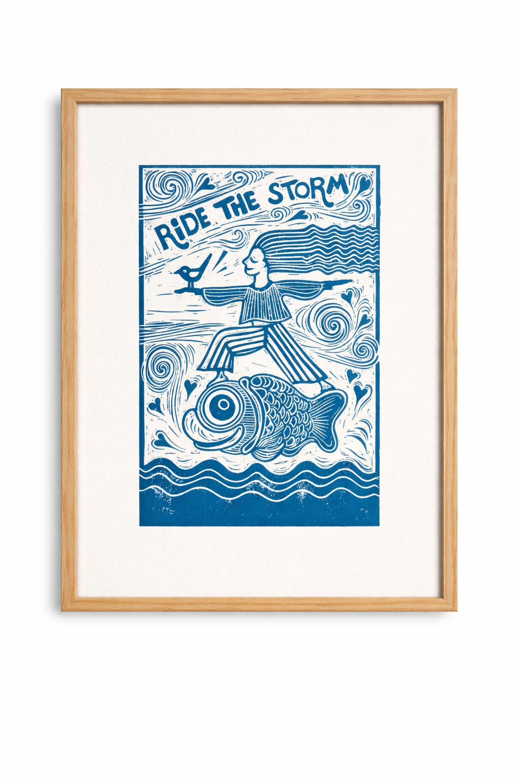 Framed artwork with a woman riding a wave and text 'Ride the Storm' on a white background.